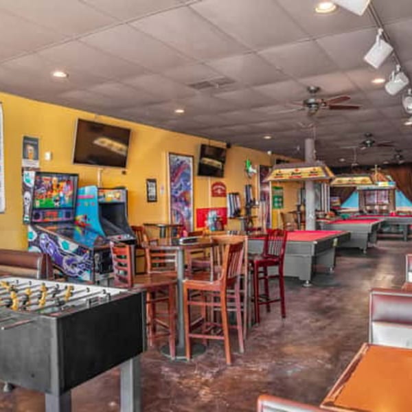 A game room at Berryhill Baja Grill with foosball, arcade games, and pool tables.