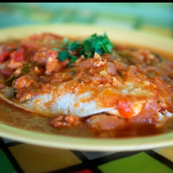 Berryhill Baja Grill's fish dish, topped with a rich red sauce and fresh green herbs.