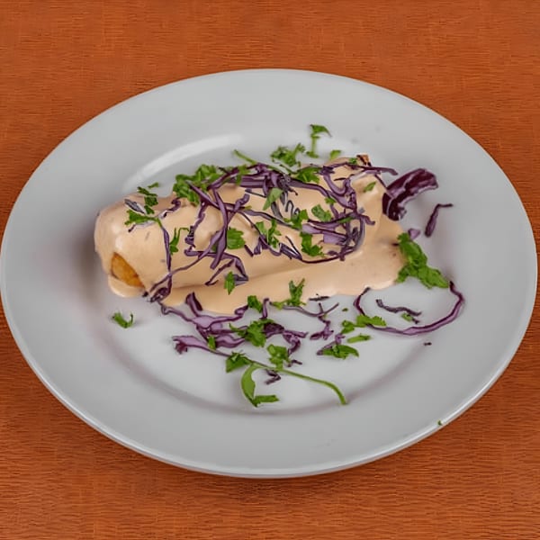 Berryhill Baja Grill's Mexican dish, a burrito covered in creamy sauce, red cabbage, and green herbs.